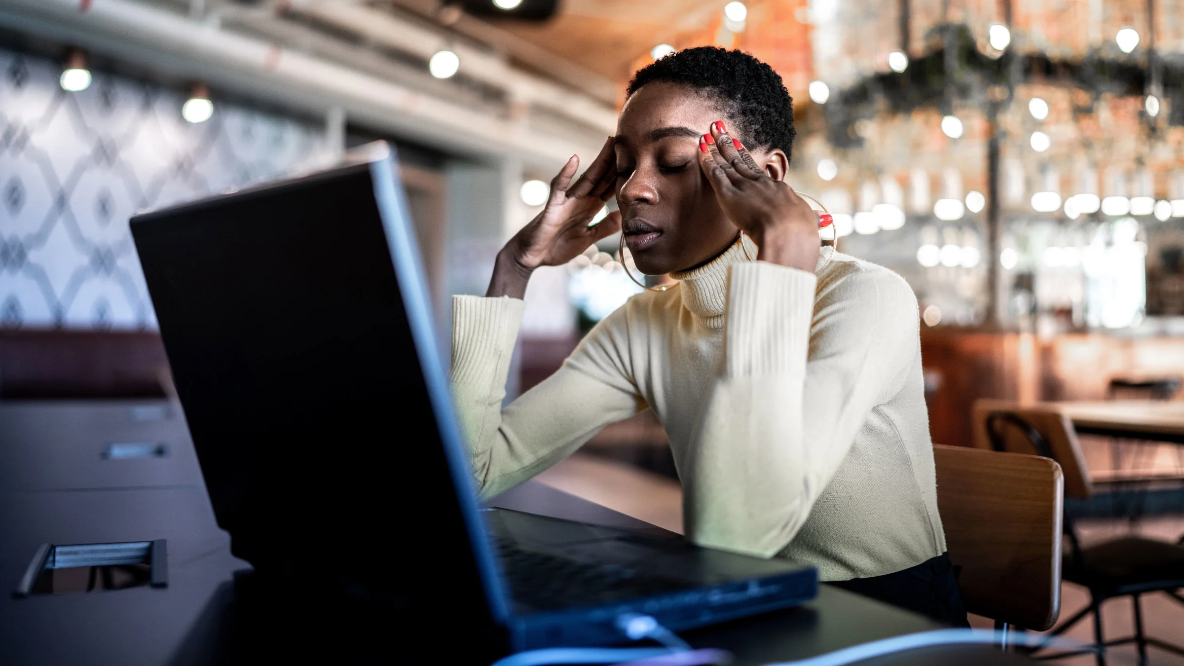 A woman is taking a break from work due to headache and pain from ear ringing.