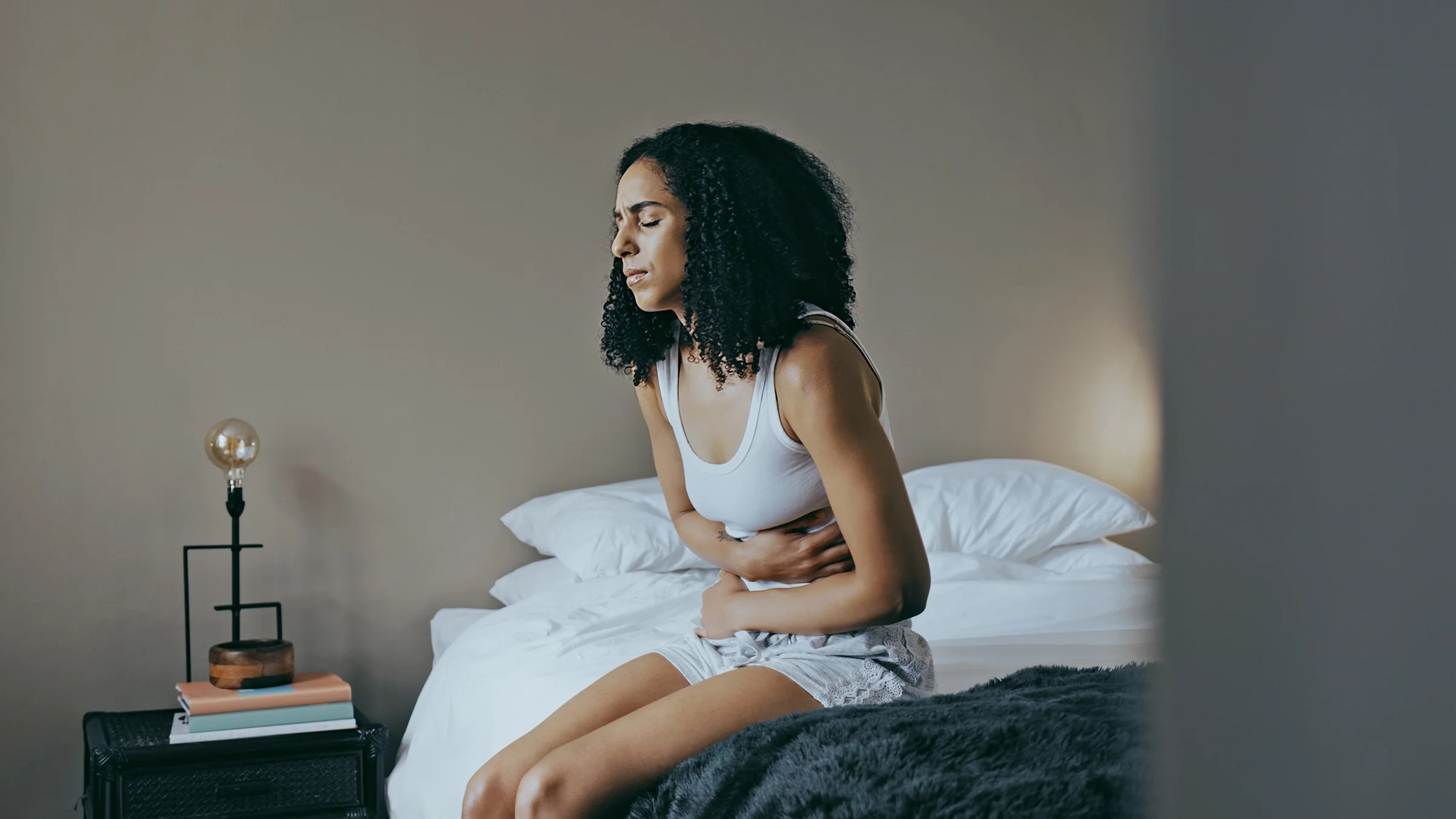 Woman hunched over with abdominal pain.