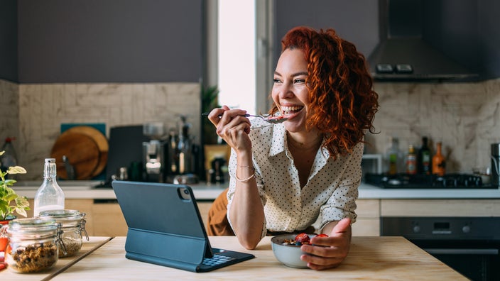 Woman enjoying her breakfast in the kitchen. 