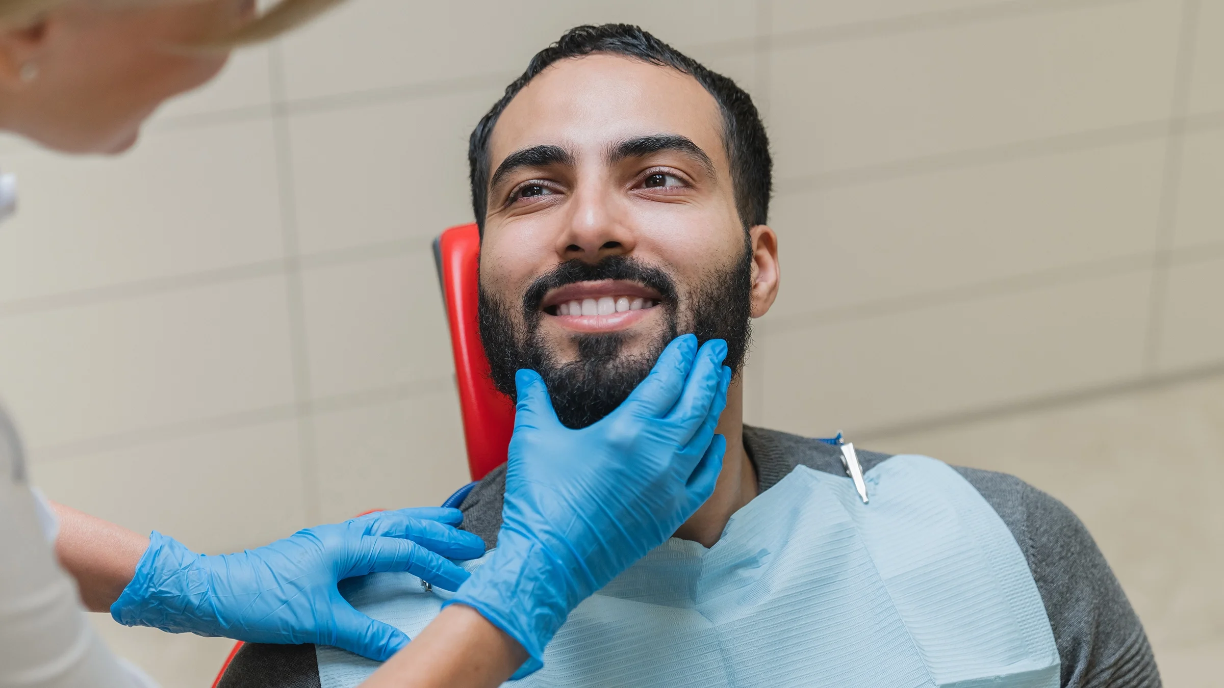 Man in dentist chair being examined by the dental hygienist.