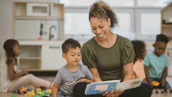 smiling preschool teacher and toddler 1295820320