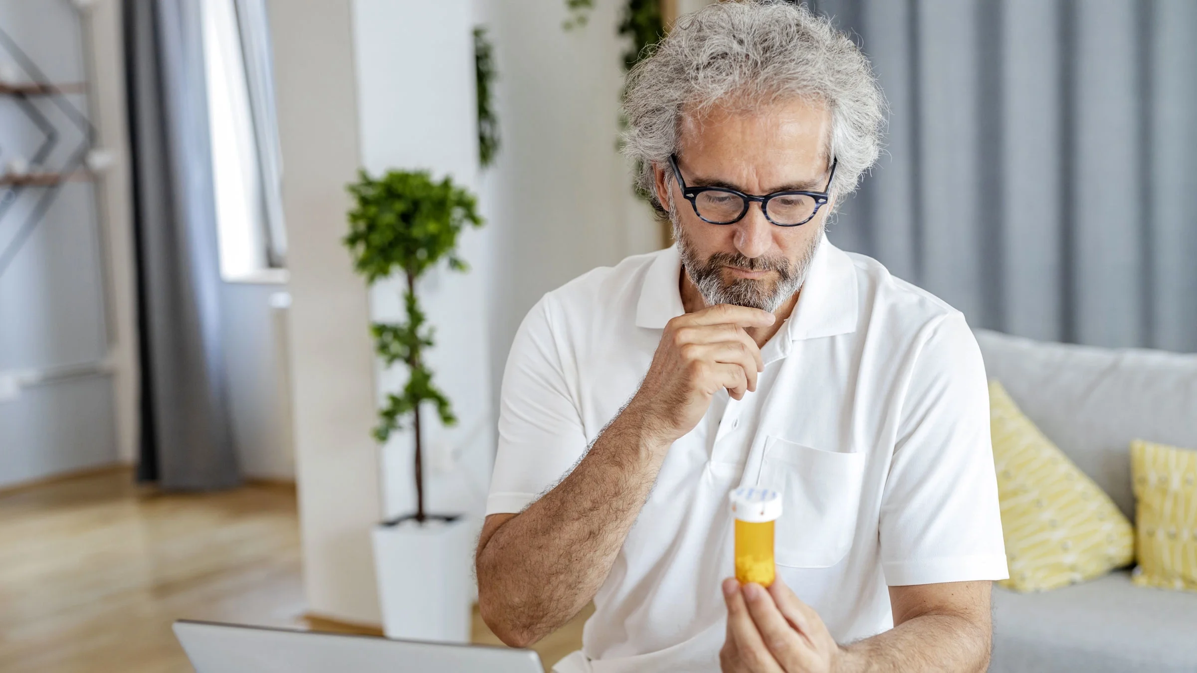 Man reading Rx label at home