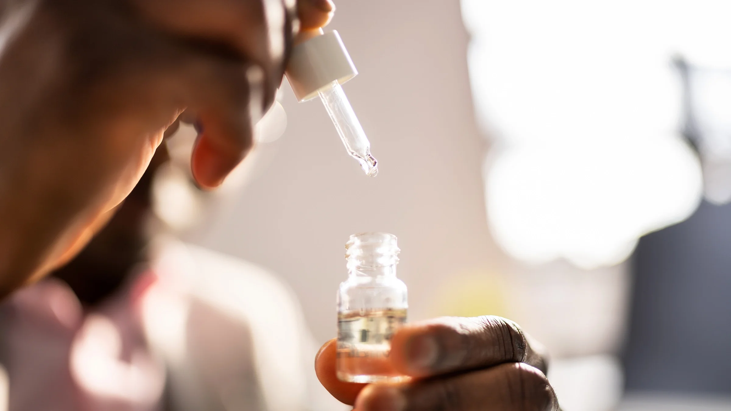 Close-up of hands holding supplement drops
