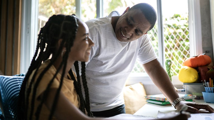 A man is helping his daughter with homework.