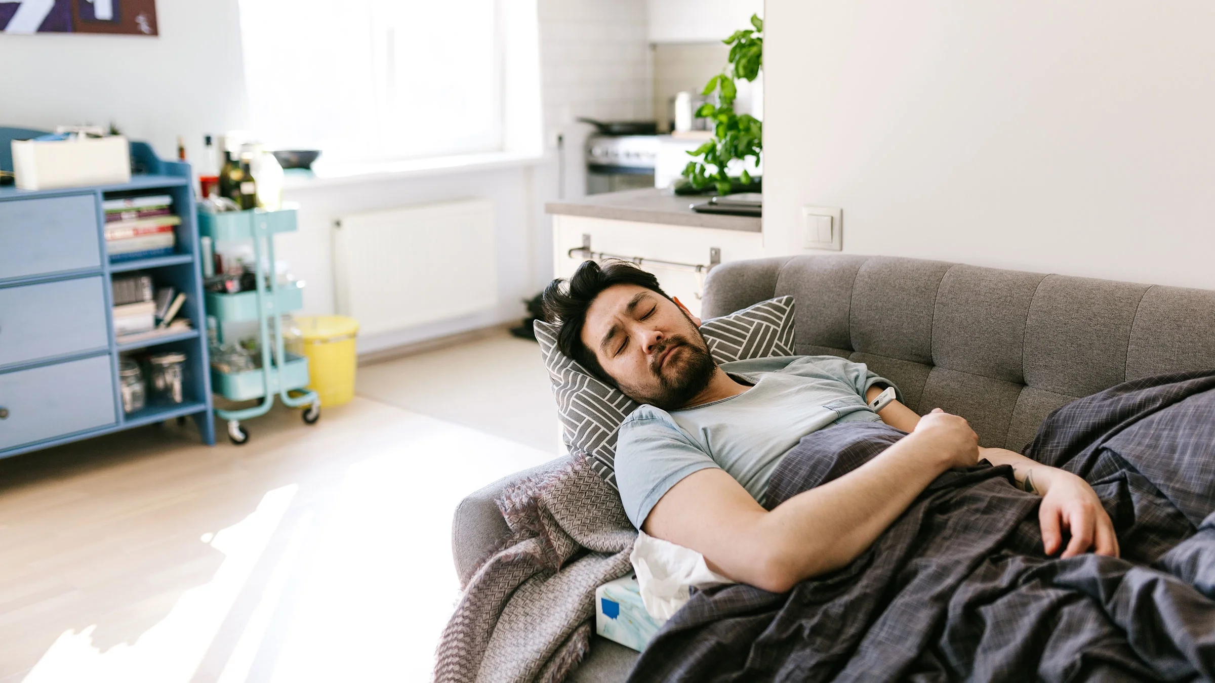 Man sick at home asleep on his sofa