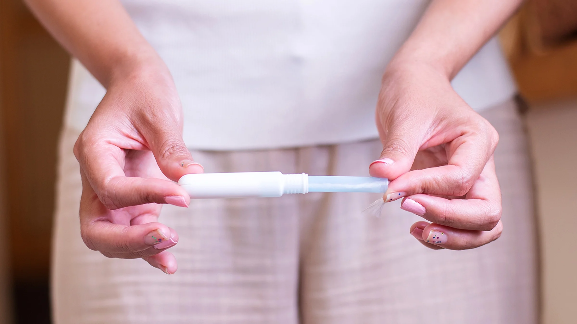 Close-up woman holding a tampon with applicator.