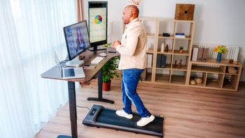 movement-exercise: man using walking pad under a standing desk 2135827763