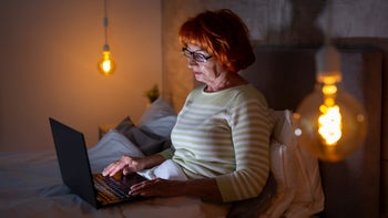 Medicare: senior citizen using laptop in bed 1197728275