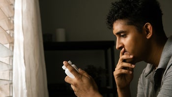 Pharmacy: man reading side of pill bottle 1592220735