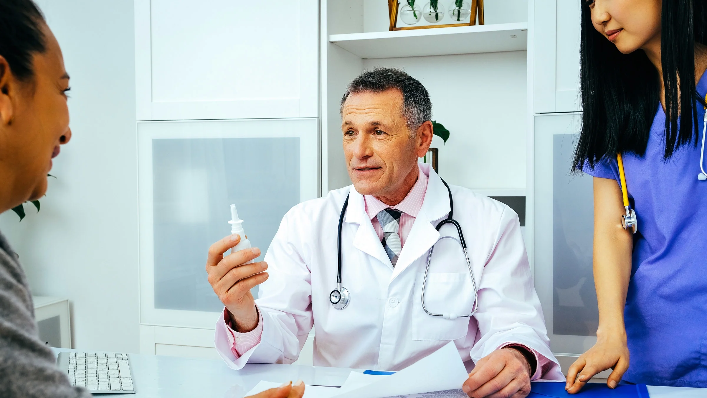 A doctor explaining a ketamine nasal spray to a patient.