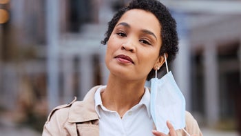 COVID-19: portrait woman taking off face mask 1440323574