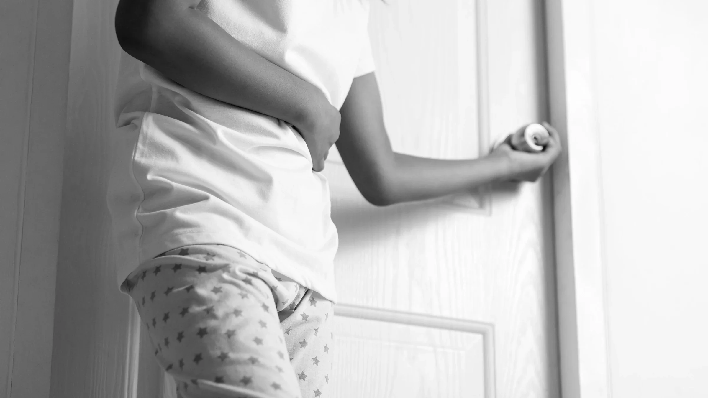 Health: side-effects: black and white cropped shot young girl opening bathroom door 1019859626