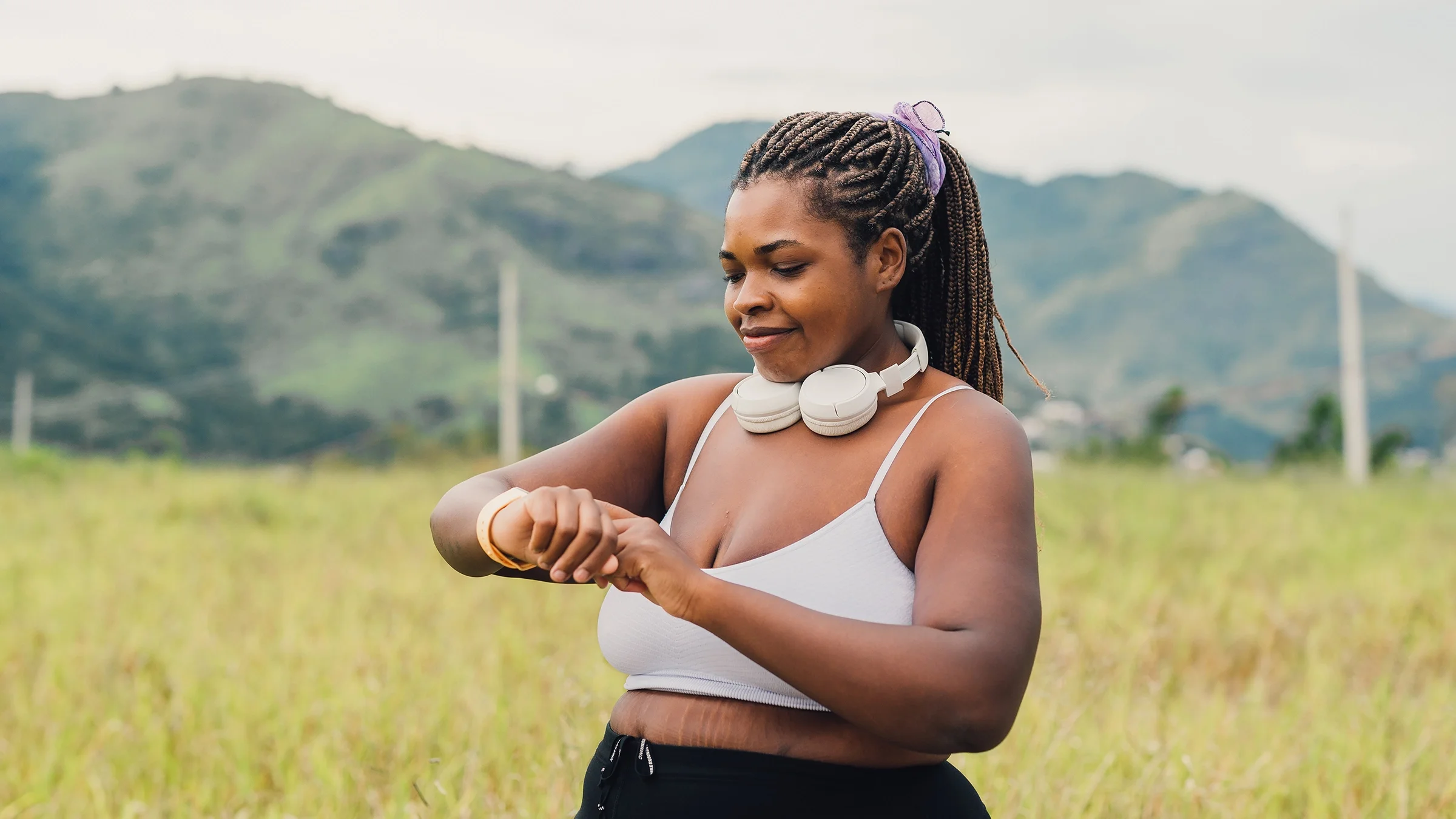 A woman sets up her smartwatch for a walk in the outdoors.