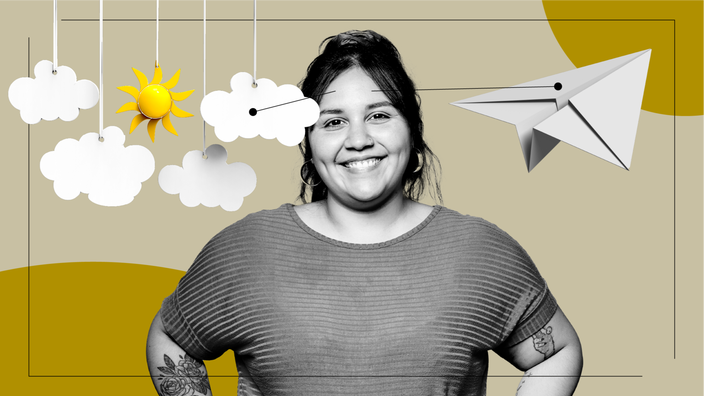 A photo of a woman smiling. Beside her are a paper airplane and  paper clouds and a sun hanging by strings. 