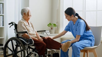 Caregiving: senior woman with nurse at home 1400091086
