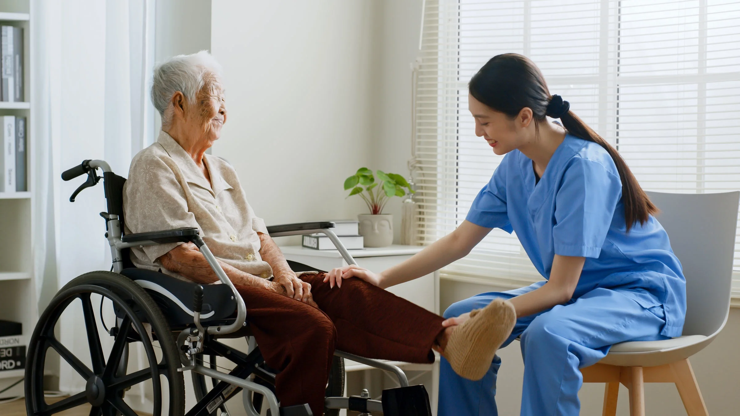 An at-home nurse examines an older woman.