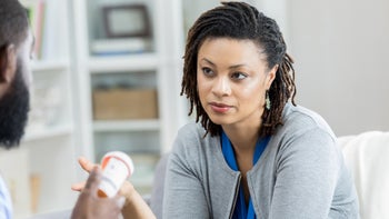 woman reviewing medication with doctor 958886976