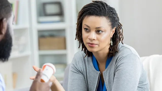 woman reviewing medication with doctor 958886976
