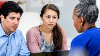 adhd: healthcare professional speaking to teen and adult 1053526704