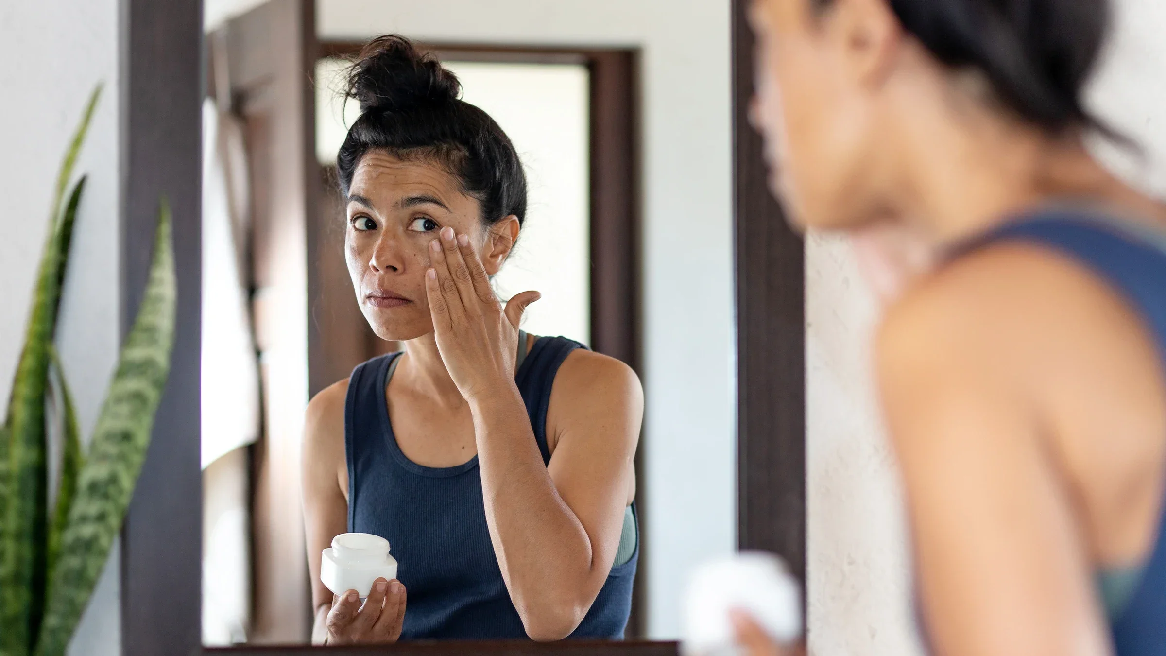 Woman applying facial moisturizing cream to her face.
MarsBars/E+ via Getty Images