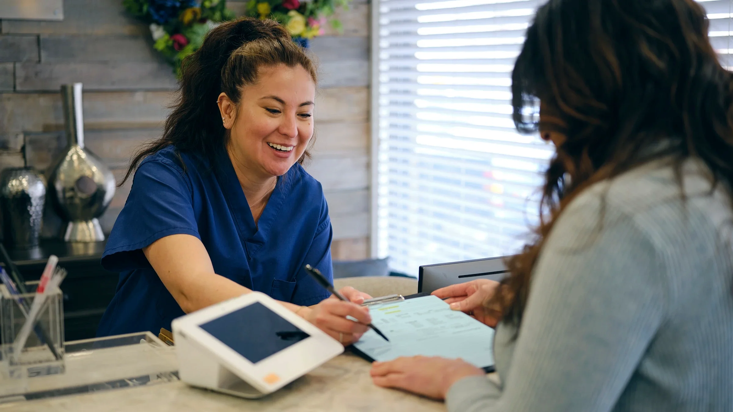 A person is signing in for their appointment at a medical clinic.
