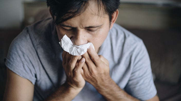 Man blowing his nose.