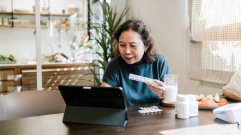 cabergoline: senior woman with pill organizer 1475432180