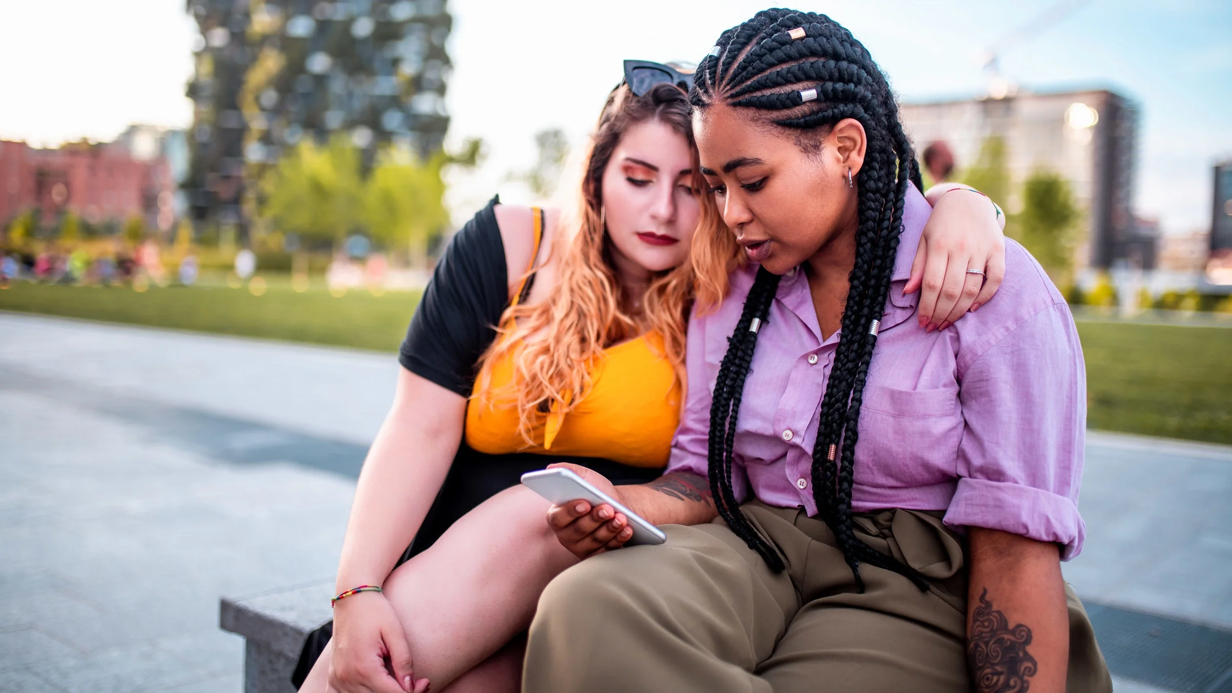 Plus-size friends looking at a phone together.