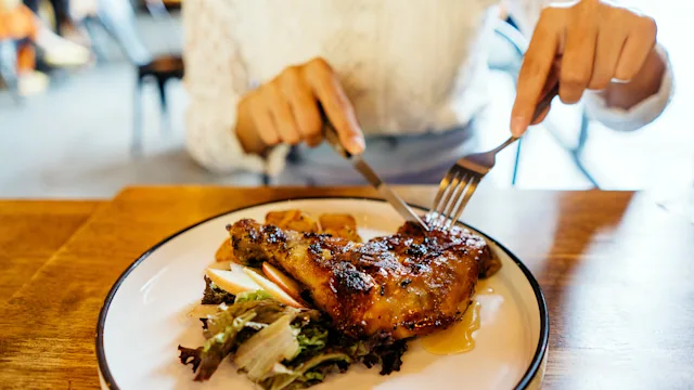 Health: Diet and nutrition: closeup woman cutting roasted chicken 1287337077
