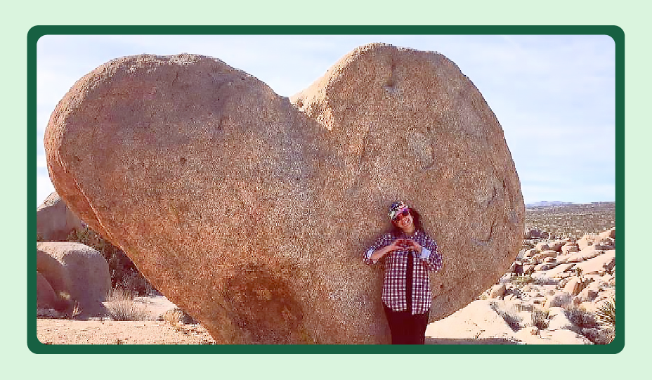 Yuri Cárdenas outdoors in front of a large, heart-shaped rock.