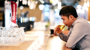 muscle-relaxants: man drinking beer alone at the bar 1126372219