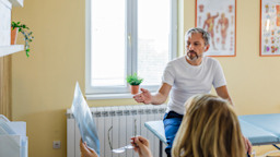 Middle aged man at the doctor’s office in an exam room. We only see the back of the doctor’s head, but she is showing the patient an x-ray or other type of scan.
RealPeopleGroup/iStock via Getty Images