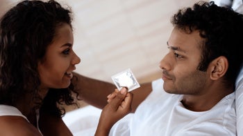 STDs: couple in bed with a condom 872561366