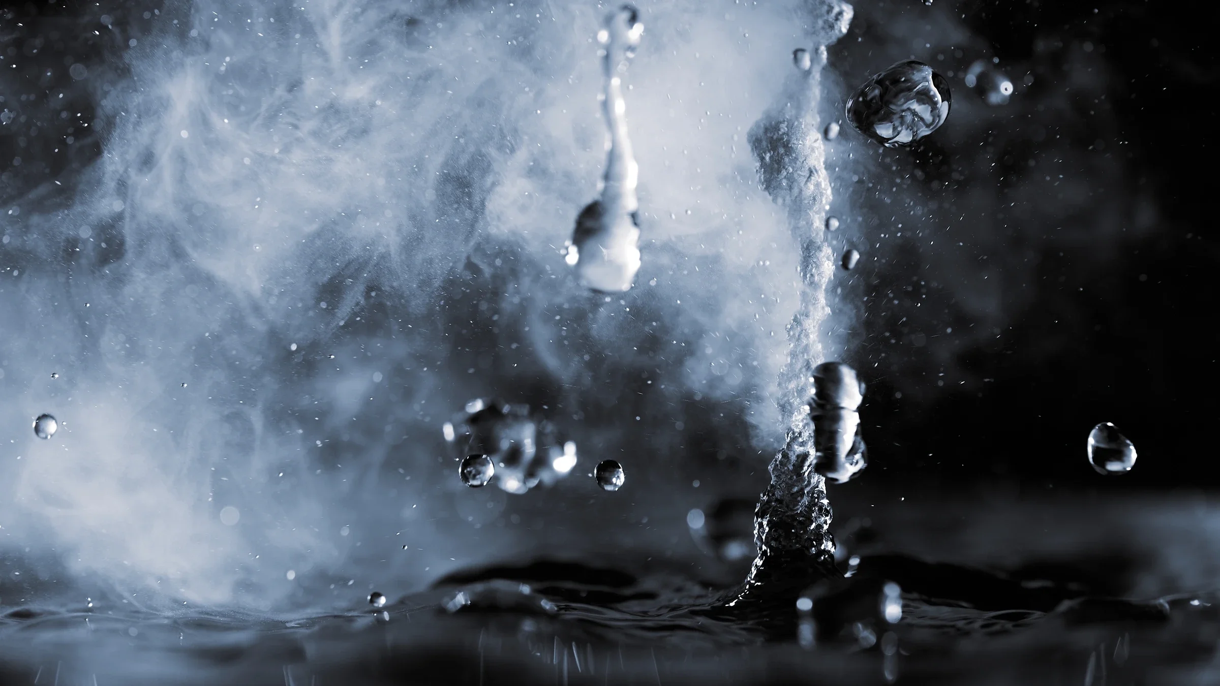 Close-up on a droplet of water and steam on a black background.