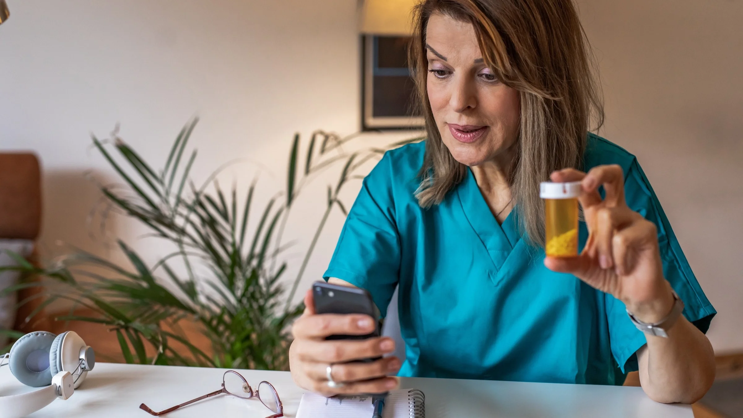 A HCP explaining a pill bottle to a patient on a video call.