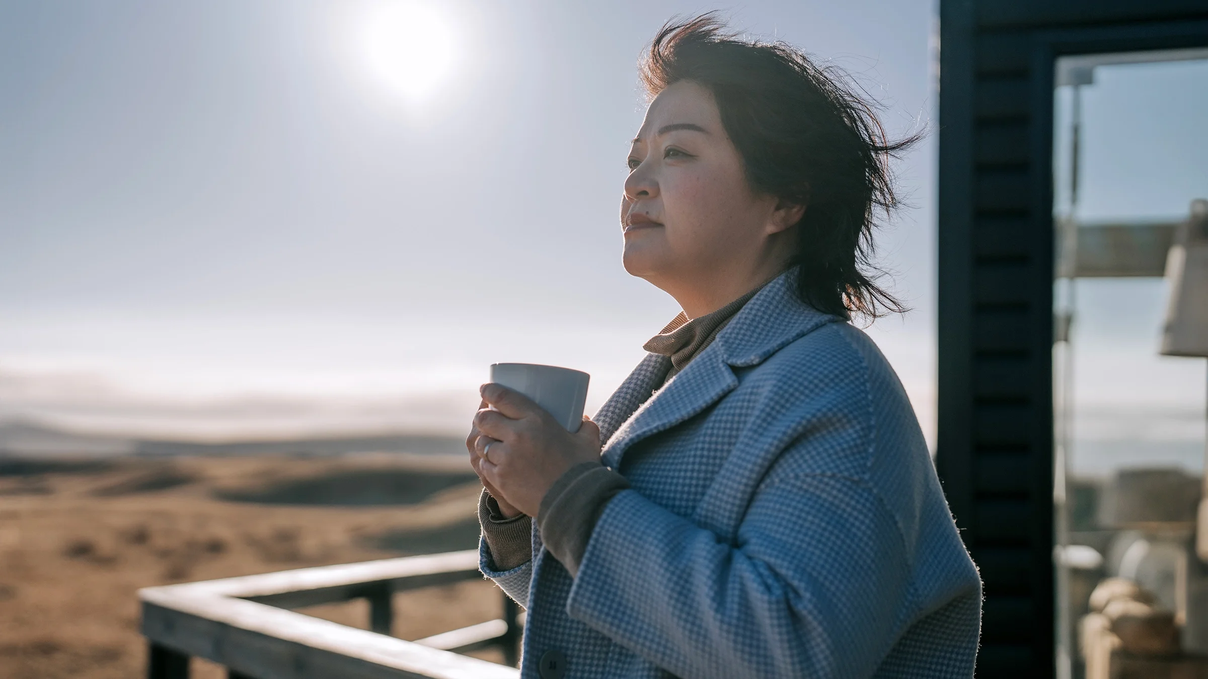 A woman drinks coffee outdoors.