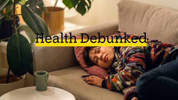 A woman takes a nap on a sofa in the living room.