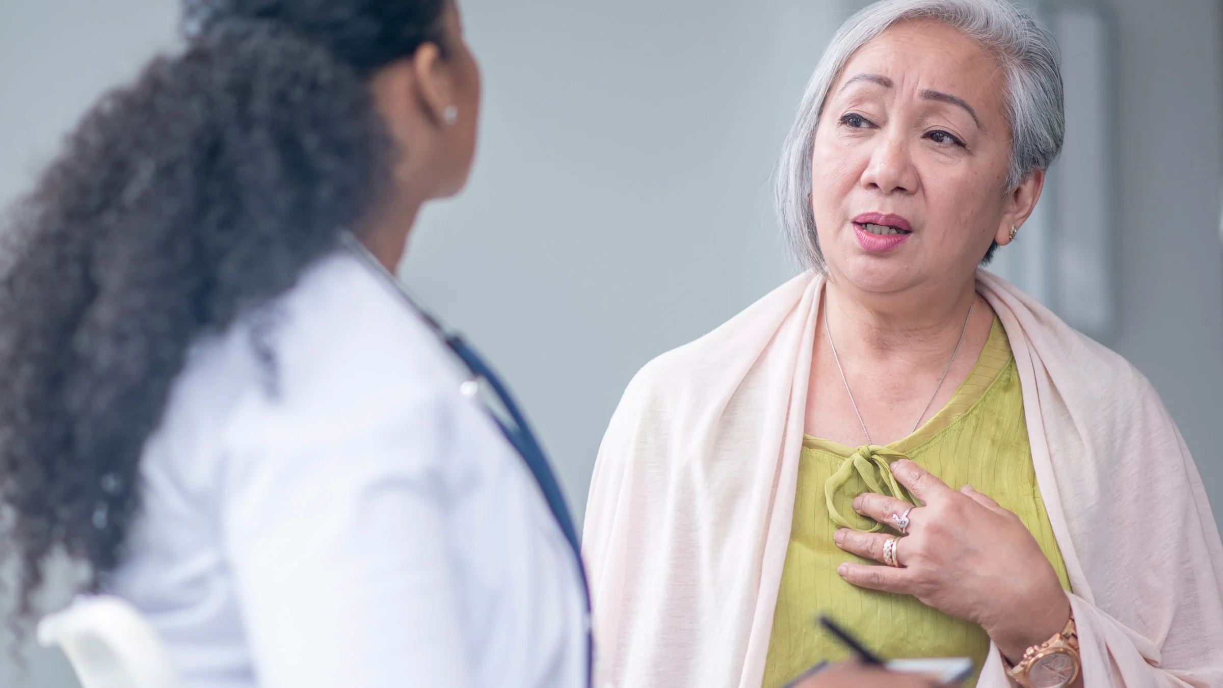 A person talking about their chest pain to their doctor.