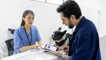 Research: man with dog at vet 2218833116