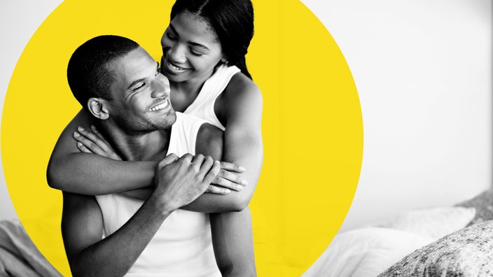 Black and white portrait of a couple with the woman draping her arms over the man’s shoulders. There is an added yellow graphic circle behind them.