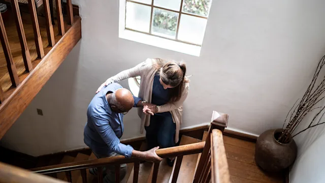 Senior health: Home fall risk: hcp helps older adult climb stairs 1313002169