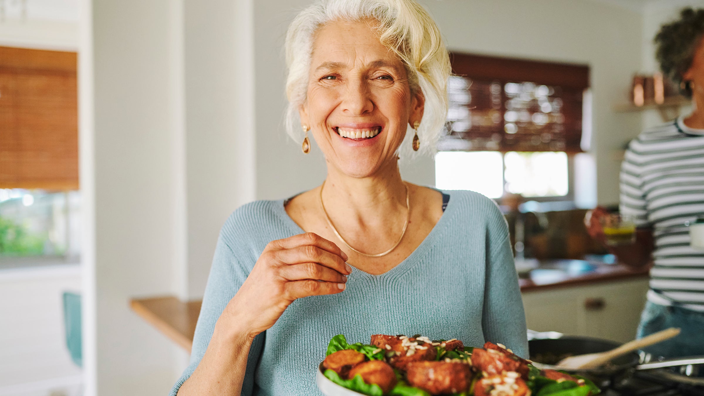 dementia: portrait of smiling woman serving dinner 2150324562