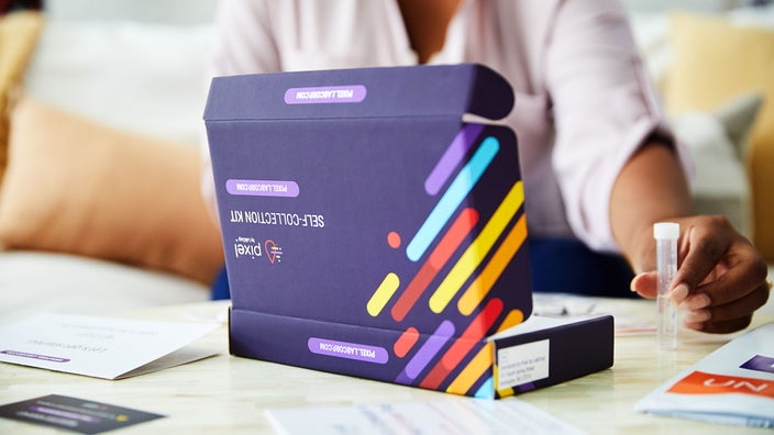 A close-up image shows a person opening a Pixel Labcorp at-home flu kit.