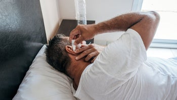 Ear: man using ear solution at home 1419575792