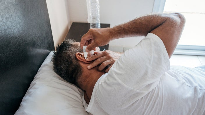 A man uses a solution to clean his earwax. There are several at-home remedies that can help remove earwax, such as ear irrigation and earwax removal drops. 