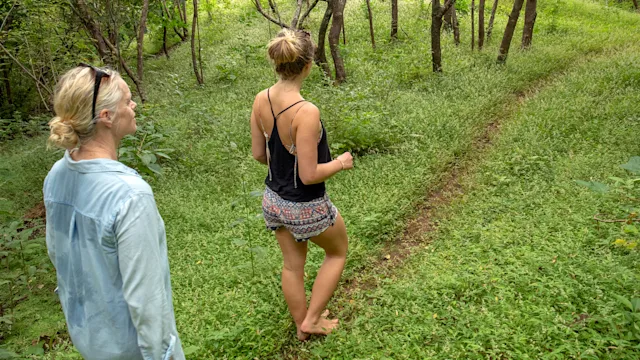 Musculoskeletal: mother and daughter walking barefoot on grass 1293785727
