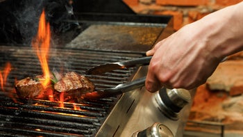 diet-nutrition: closeup hand grilling steak on open flame 836589598