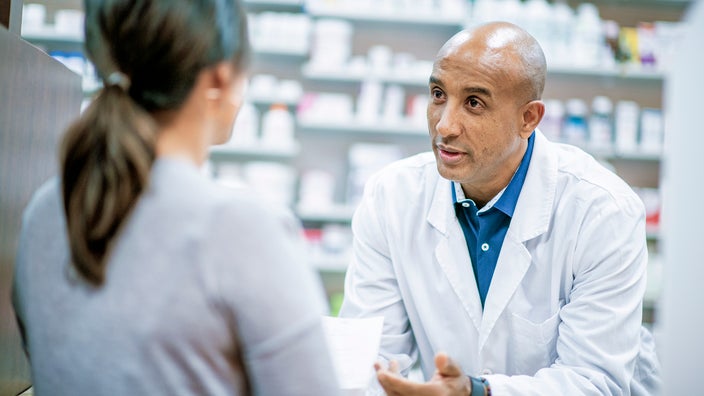 Pharmacist having a consultation with a patient at the pharmacy counter.