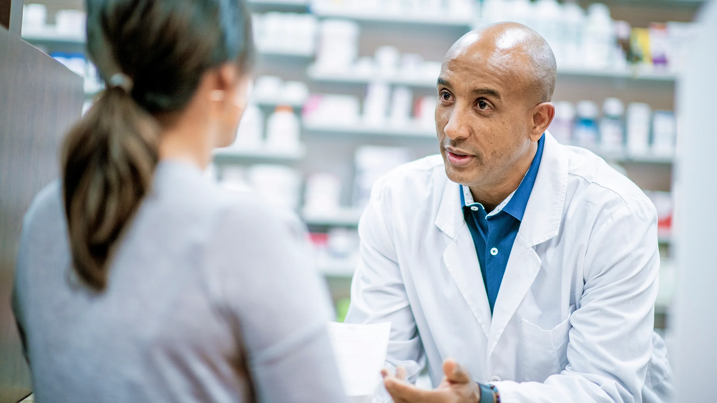 Pharmacist having a consultation with a patient at the pharmacy counter.