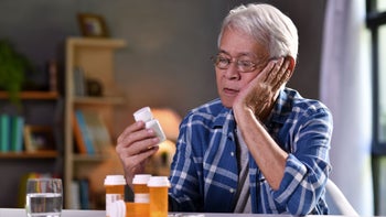 Health: Buspirone: senior man reading rx bottle 1169351816